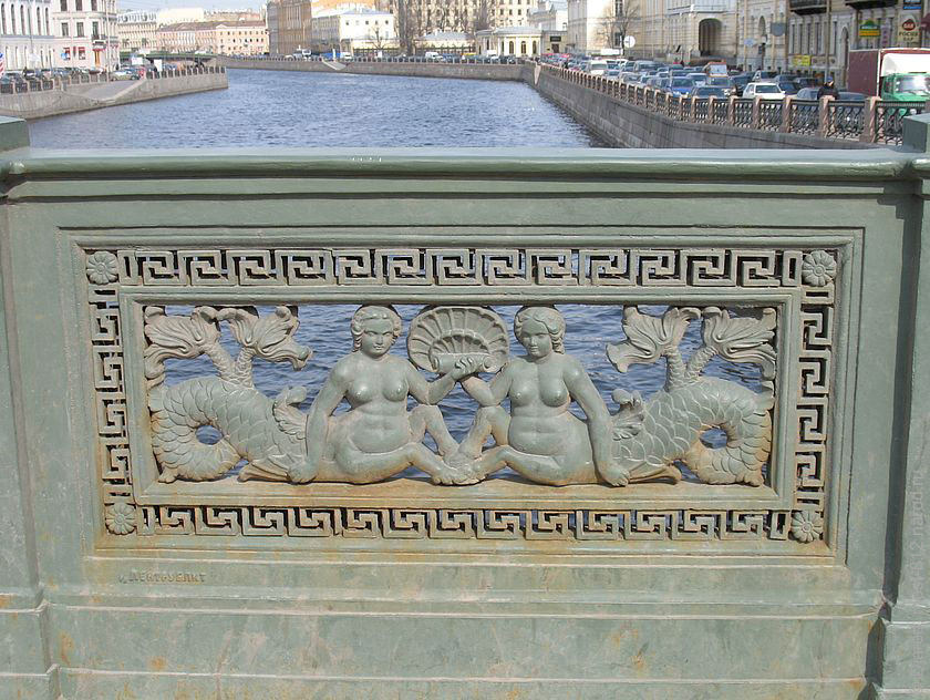 Чугунная решетка ограждения Аничкова моста, украшенная греческим узором и изображениями двух русалок с морской раковиной.