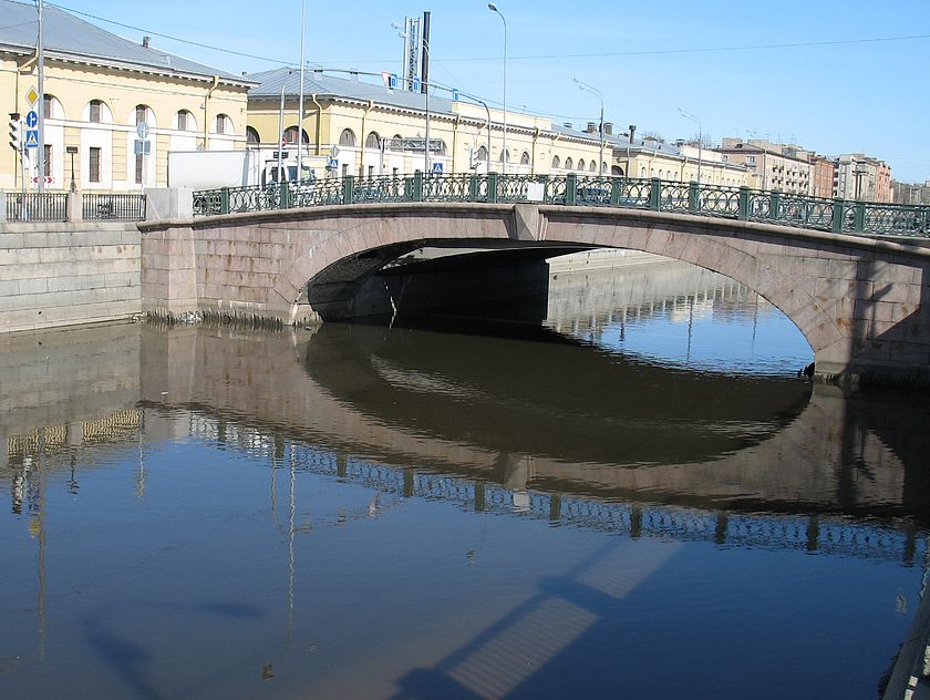 Балтийский мост и его отражение в водах Обводного канала. Полукруглый свод мостового пролета облицован гранитом.